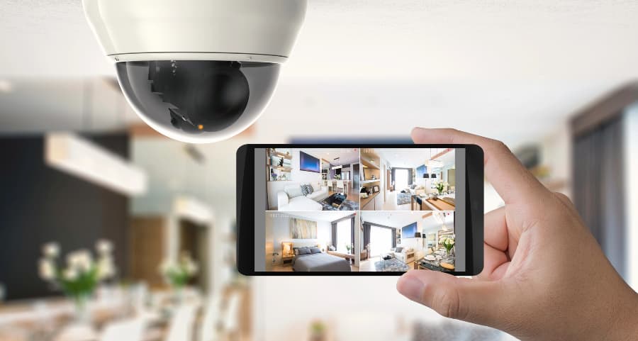 Homeowner holding smartphone with video feed from security cameras in New York City