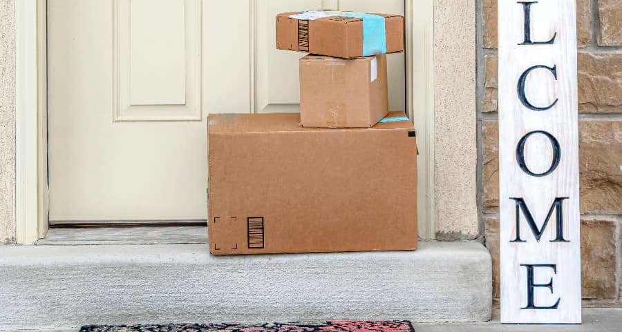 Packages on the doorstep of a home with a welcome sign in New York City